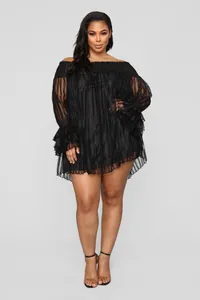 Détail de robe noire à épaules dénudées avec texture ondulée et manches à volants