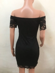 Dettaglio di un vestito in pizzo nero con motivi floreali e bordi in pizzo ciglia raffinati