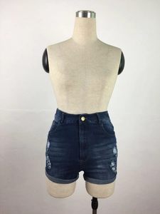 Detail of high waisted distressed denim shorts with cat whiskers wash and rolled hemline