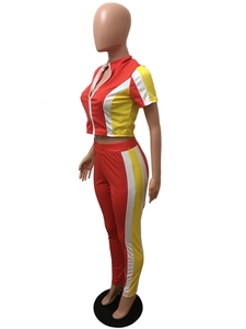 Detail view of red, yellow, and white color-block athletic two-piece tracksuit with cropped top