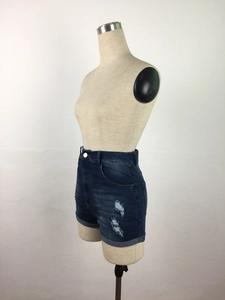 Detail view of high-waist denim shorts with ripped accents and vintage wash texture