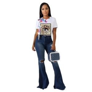 Women's white eye-graphic t-shirt and distressed flare jeans with denim handbag
