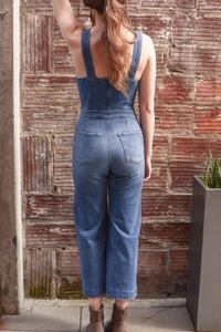 Rear view of slim fit denim jumpsuit with classic pockets and back stitch details