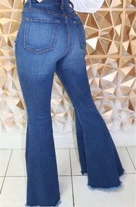 Close-up of retro flare jeans with distressed raw hem and back pocket detail
