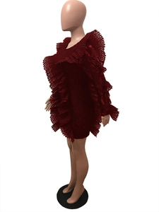 Dettaglio dell'abito in pizzo bordeaux con balze a strati e texture floreali