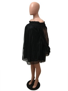 Détail d'une robe noire à épaules dénudées en maille avec dentelle texturée et volants