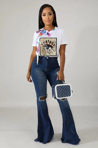 Detail of high-waisted flared jeans with knee rips and raw hem denim texture