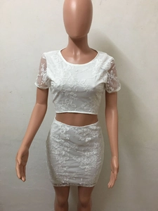Détail d'un ensemble deux pièces en dentelle blanche avec broderie florale et jupe