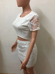 Détail de la dentelle florale blanche brodée sur cet ensemble haut court et mini-jupe