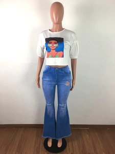 Close-up of high waist flared jeans with distressed holes and frayed raw hems