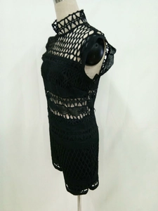 Detail of black crochet mock neck sleeveless romper with geometric lace cutouts