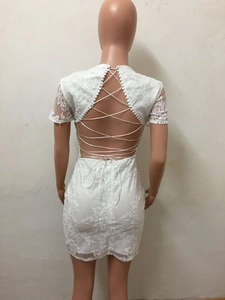 Détail de la robe en dentelle blanche avec laçage croisé au dos et broderies florales