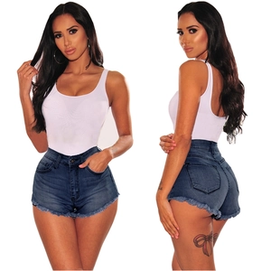 Detail of high waisted distressed denim shorts with frayed edges and ribbed white tank top