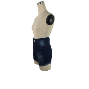 Detail view of high waist dark blue denim shorts with metal button on mannequin