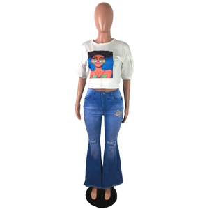 Close-up of high-waist flared blue jeans featuring distressed knee holes and frayed raw hems