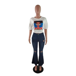 Detail of high waist flared jeans with distressed knee holes and frayed raw hem design