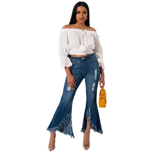 Women's off-shoulder lace top with distressed flare jeans and raw fringe hemline