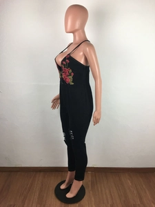 Detail of red floral embroidery and ripped knee on black denim jumpsuits for women