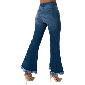 Macro detail of dark blue high-waisted flare jeans with raw frayed hem and tassel trim