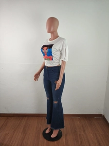 Detail of high waisted flare jeans with distressed ripped knees and raw hem edges