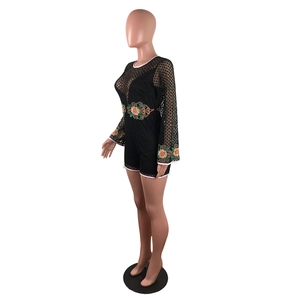 Detail of floral embroidery on black lace long sleeve romper with white piping