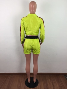 Achteraanzicht van neon groen trainingspak met sportieve zijstrepen op mouwen en short