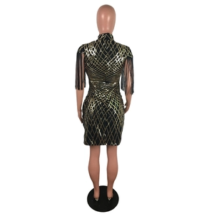 Détails des paillettes dorées à motifs losanges et des franges sur la robe courte