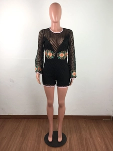 Detailed close-up of floral embroidery on black lace long-sleeved romper with open back