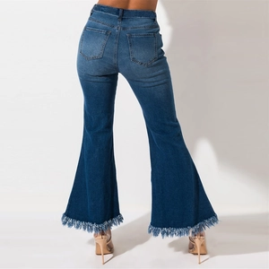 Detail of high waisted flared denim jeans featuring chic raw fringe hem and washed blue fabric