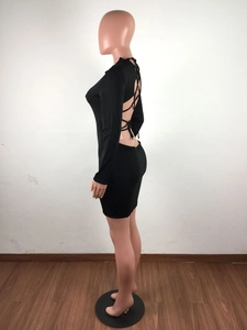 Detail of cross-bandage backless design on a long-sleeved black bodycon dress