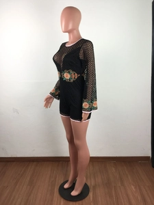 Detailed embroidery on black lace playsuit featuring floral patterns and flared sleeves