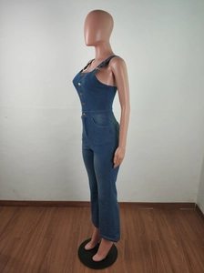 Detail view of denim jumpsuit showing slim fit bodice and metallic button accents