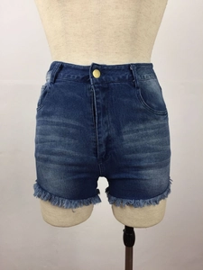 Detailed view of high-waisted denim shorts featuring frayed hems and vintage washed texture