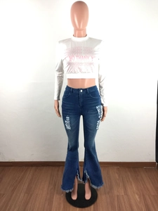 Detail view of high-waist flared jeans featuring ripped knees and distressed fringe hems