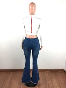 Detail of flared denim jeans with raw fringe hem and back red zipper on crop top
