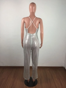 Detail of silver sequin jumpsuit showing deep backless design with white crisscross straps