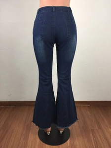 Détail des poches arrière et ourlets effilochés du jean évasé à taille haute