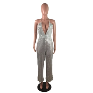 Detail of silver sequin jumpsuit featuring a deep V-neckline and backless halter design
