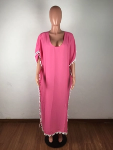 Détail du cache-maillot de plage rose avec bordures à pompons blancs et col en V profond