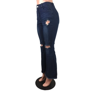 Détails d'un jean évasé bleu foncé avec genoux déchirés et bords effilochés
