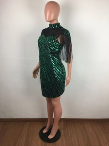 Detail of emerald green sequin dress with mesh V-neckline and long black fringe trim