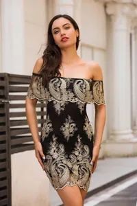 Vue détaillée de la broderie en dentelle dorée sur une robe courte noire à épaules dénudées