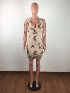 Détail d'une mini robe rose à paillettes avec col en V et manches longues en résille