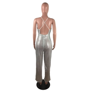 Detail view of silver sequin jumpsuit featuring white crisscross back straps and deep V-cut