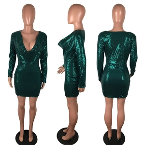 Macro detail of emerald green sequin dress with deep V-neck and sparkling textures