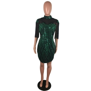 Détail des paillettes vertes et franges noires sur une robe de soirée moulante