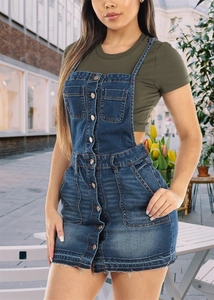 Detail of dark blue denim pinafore dress with metal buttons and frayed hem edge