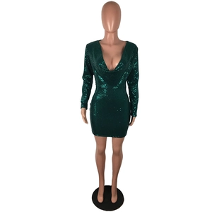 Close-up of dark green sequin party dress with deep V-neck and long sleeves on mannequin