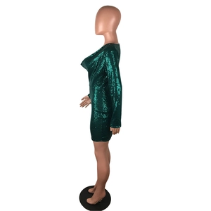 Close-up of emerald green sequin mini dress with shimmering fabric and slim fit design