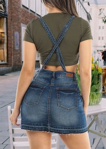 Detail of the cross-back denim suspender dress and cropped t-shirt on a model